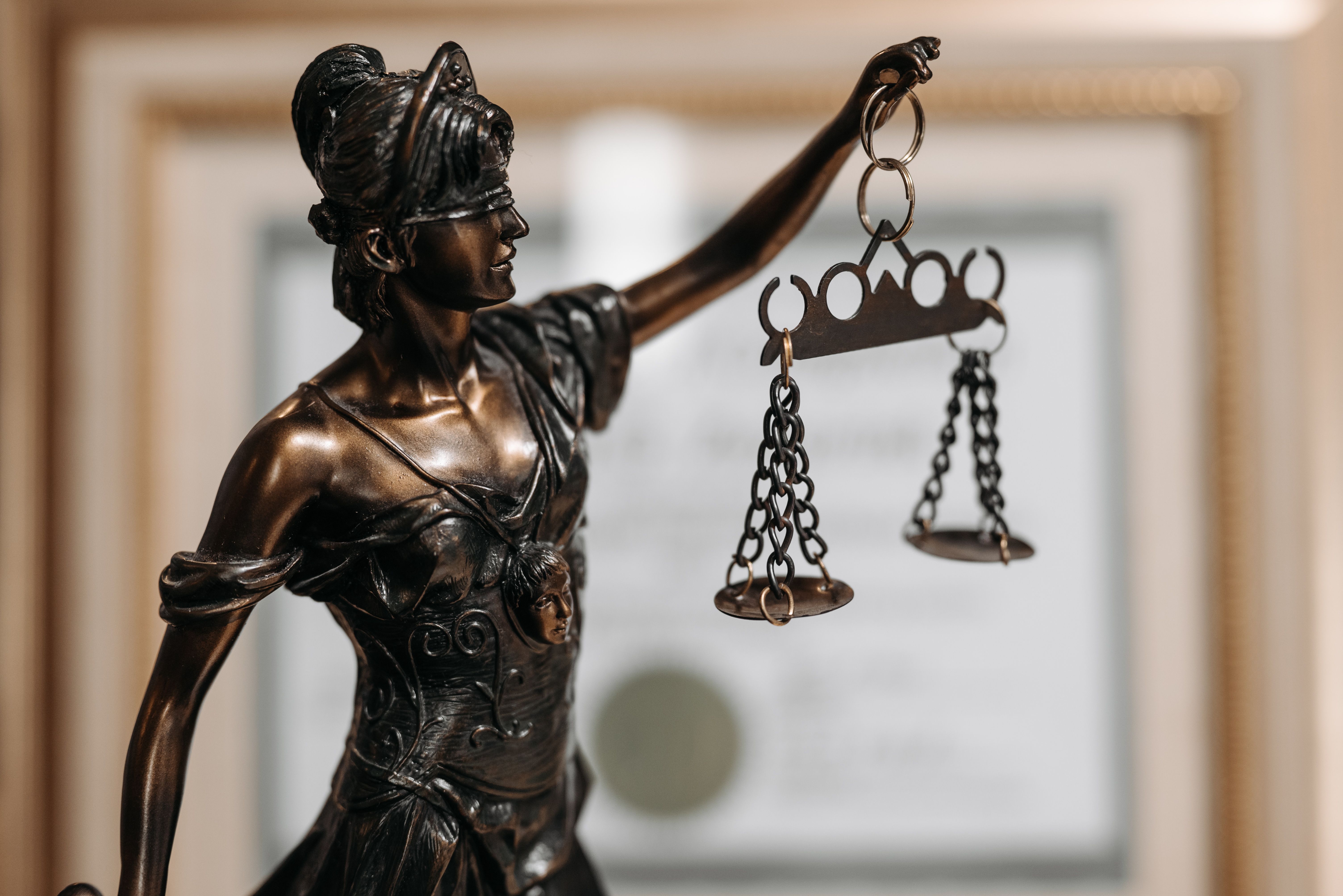 Lady Justice holding scales, symbolizing the comparison between business debt and equity financing.