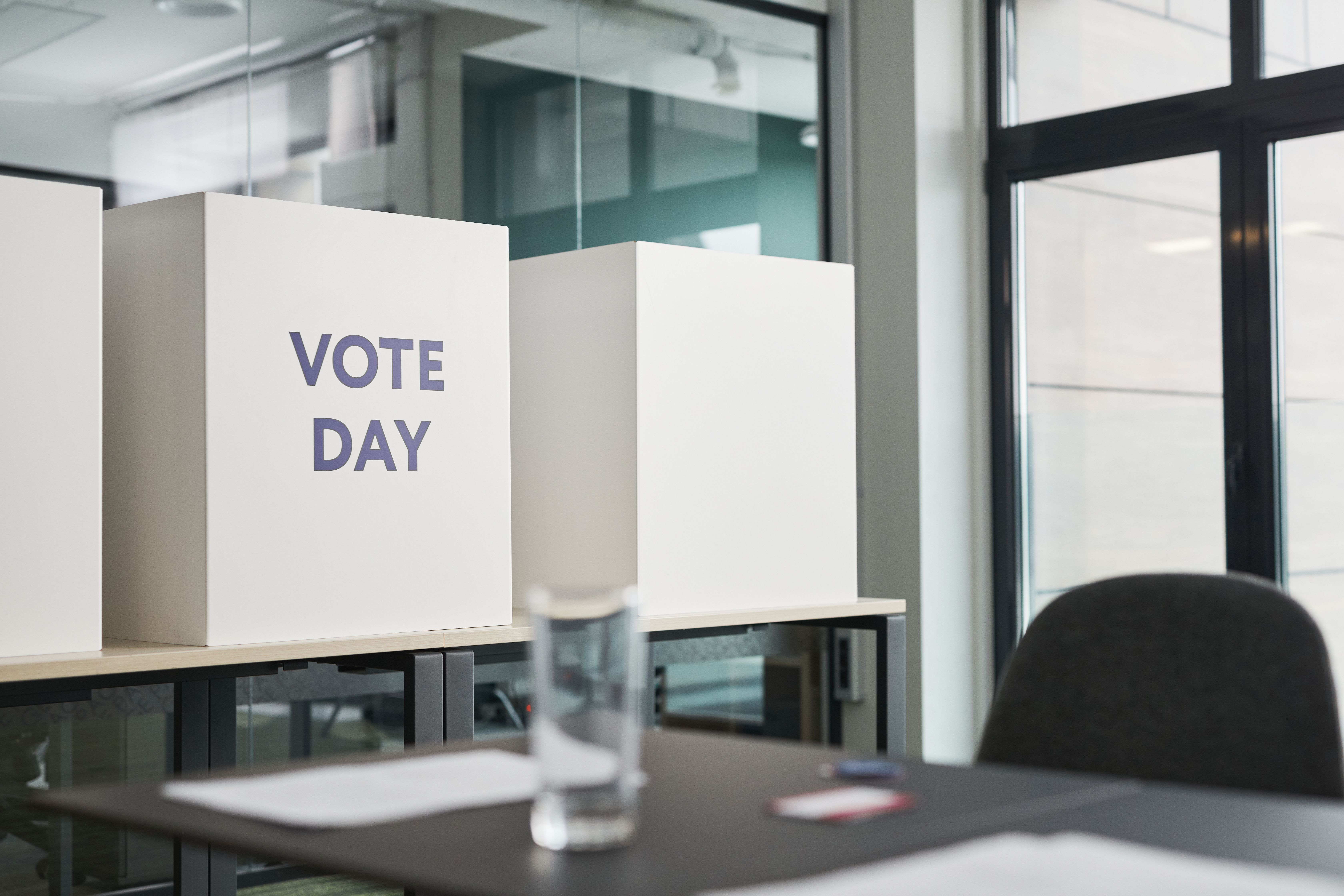 Voting booths in an office, representing public confidence in fair civic institutions