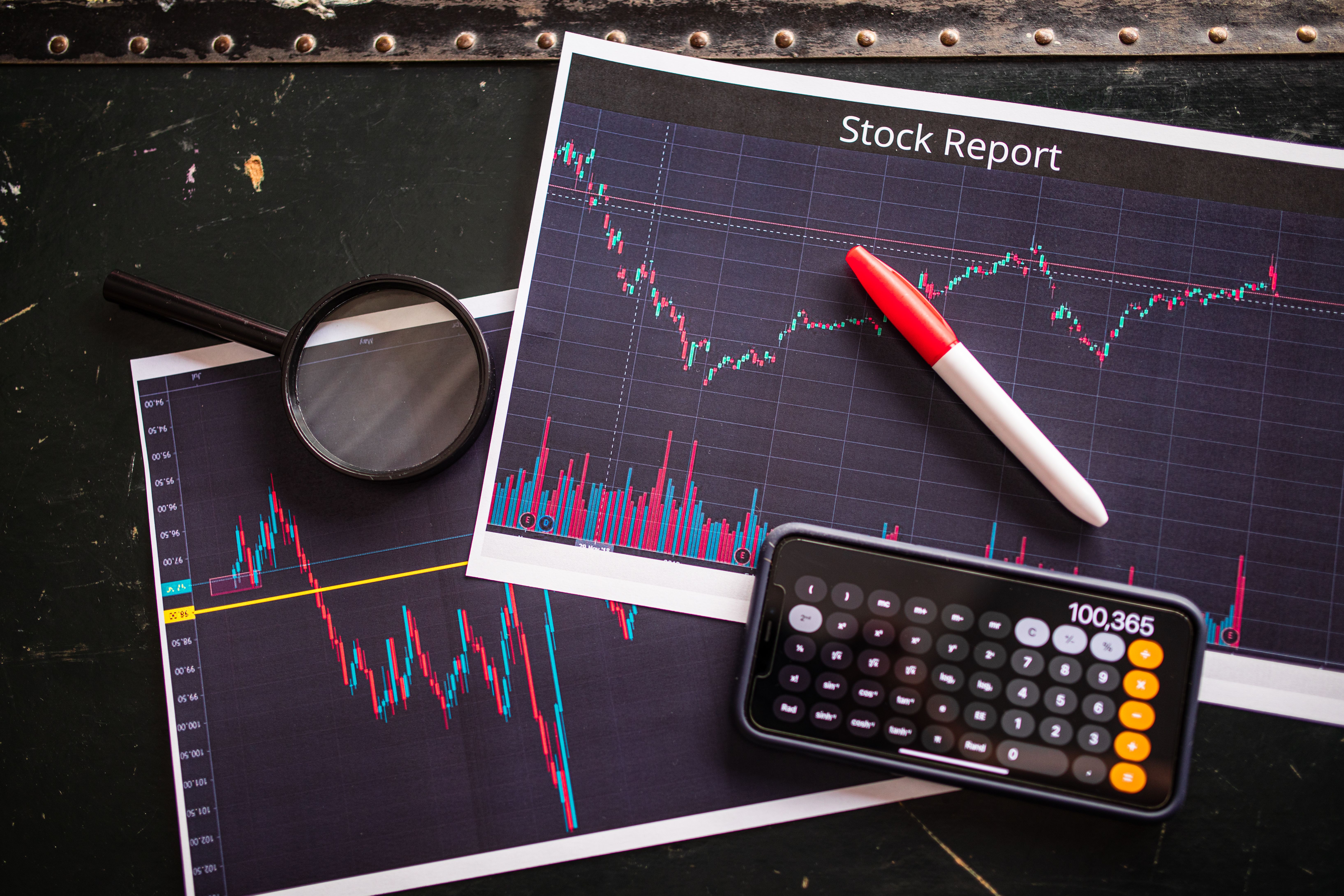 Stock report with charts, calculator, and magnifying glass for financial analysis