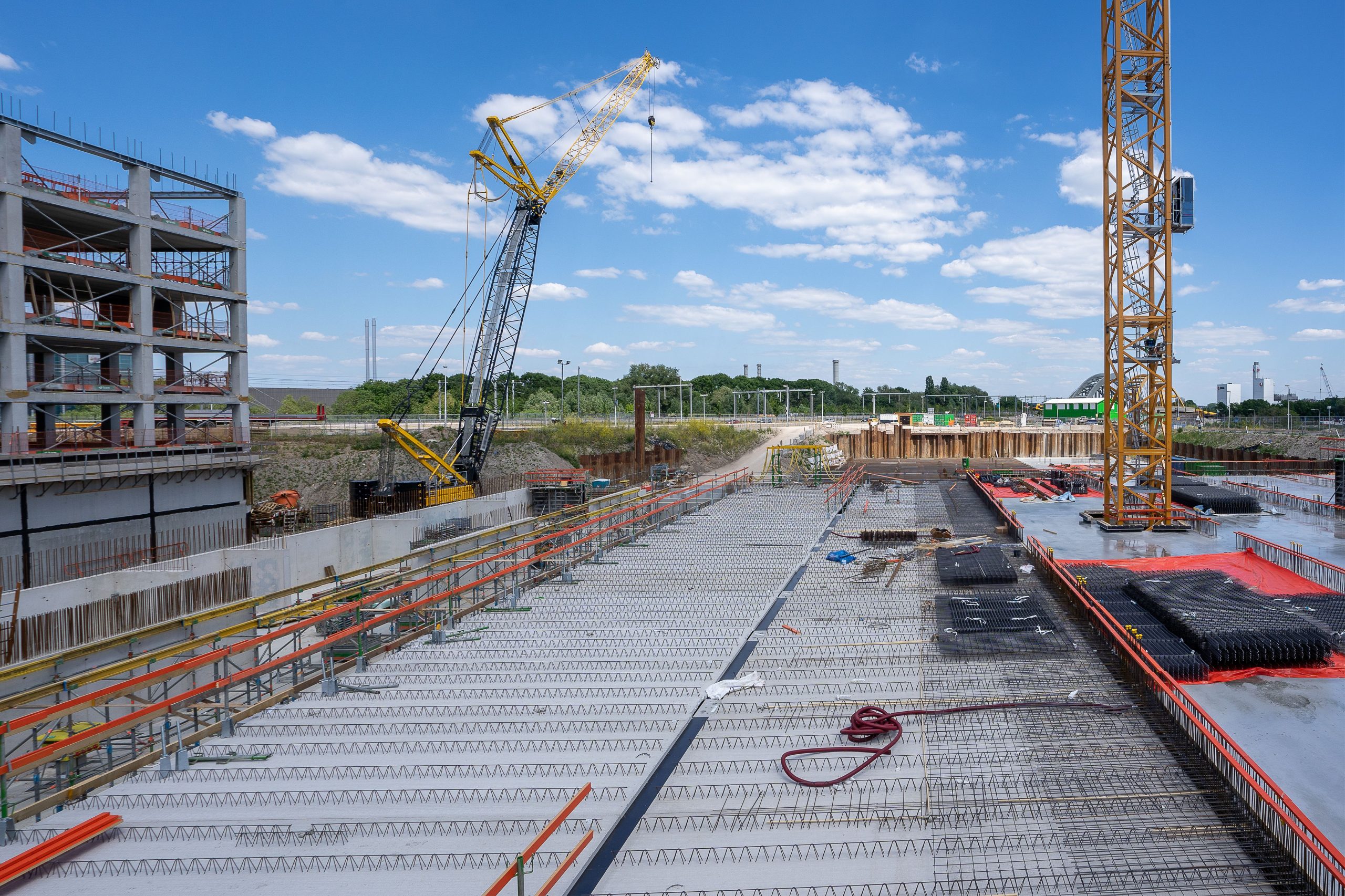 Busy construction site with cranes and building structure under a clear sky