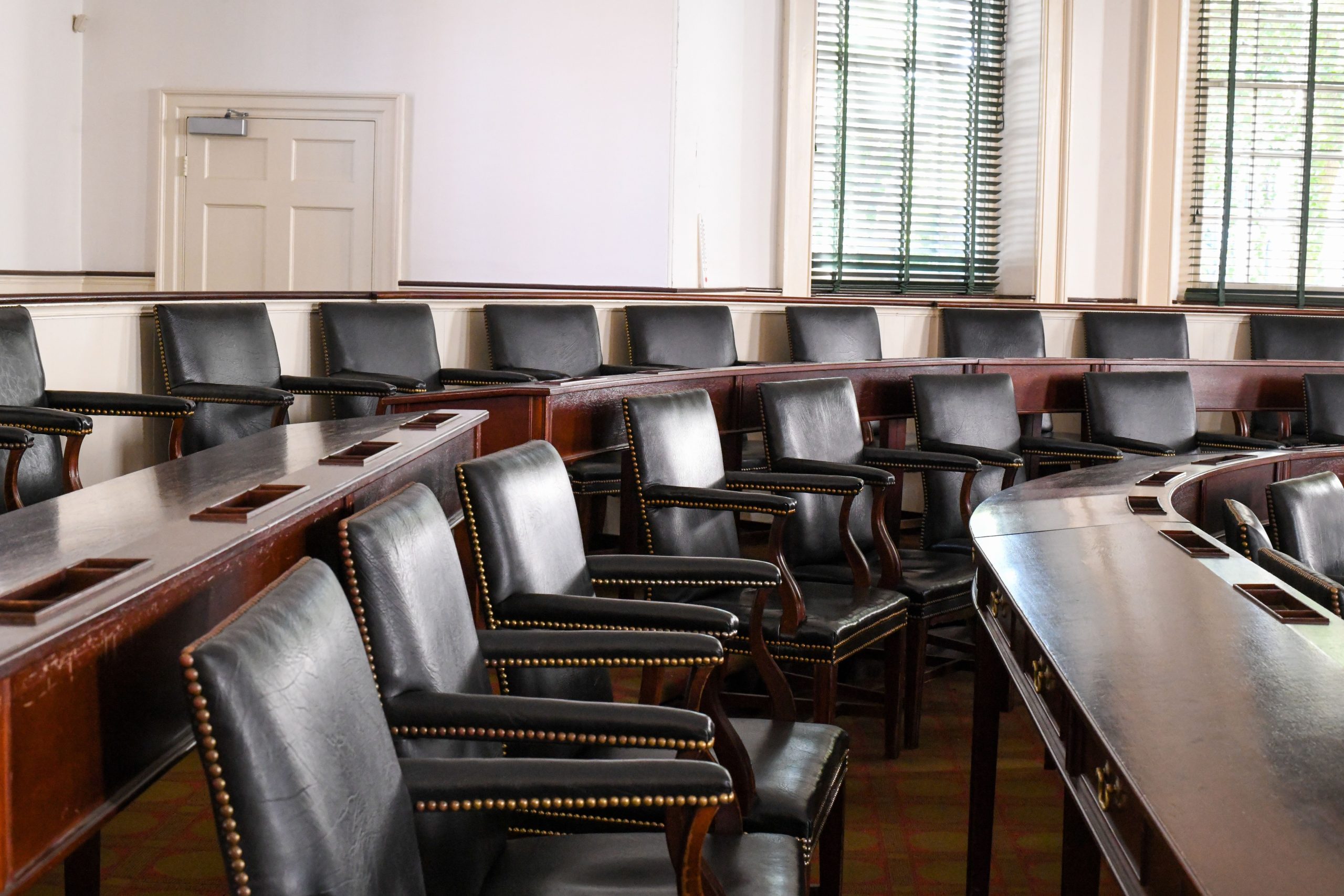 Empty legislative chamber representing formal public oversight and democratic accountability