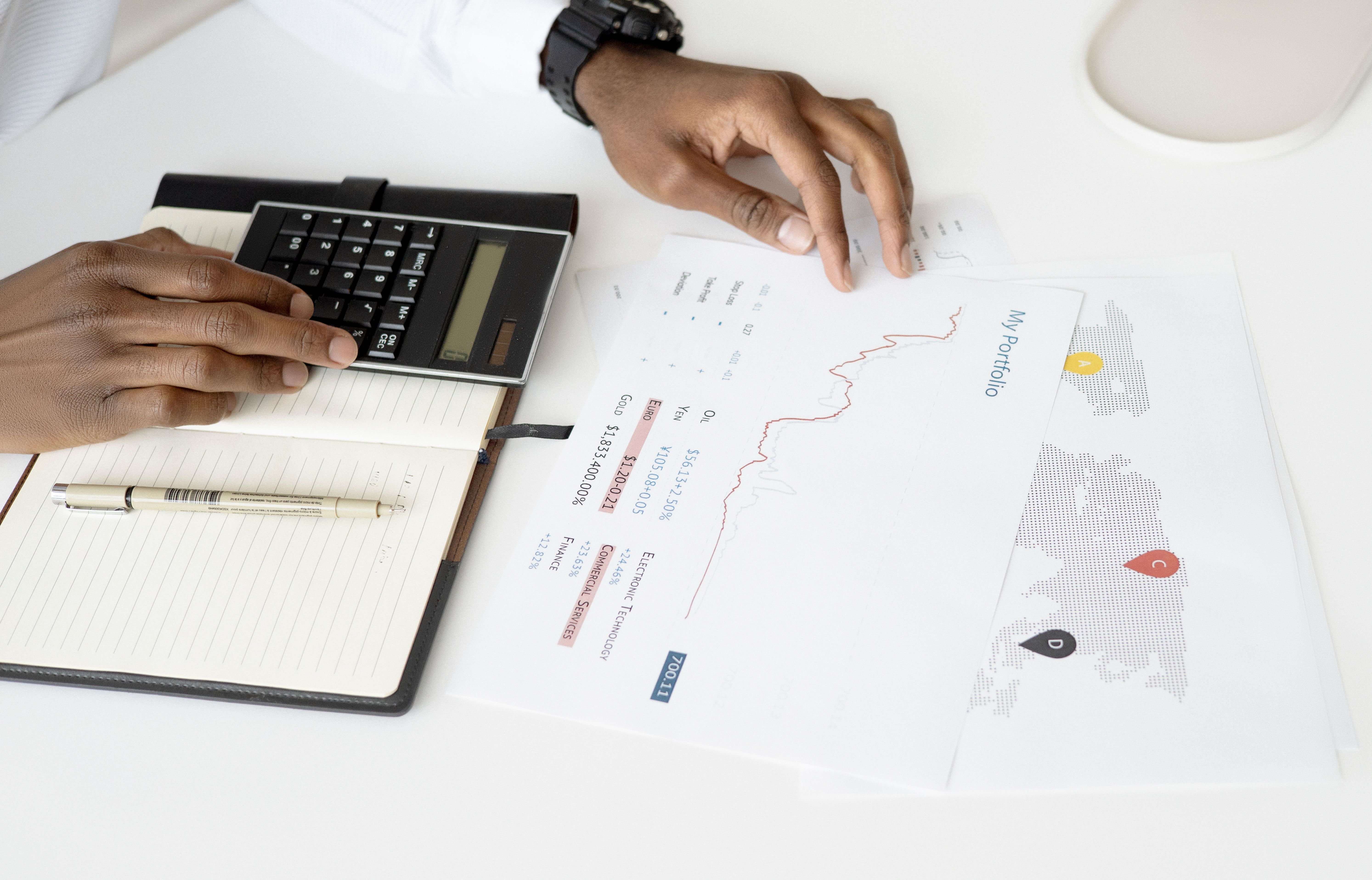 Overhead view of a person analyzing financial documents with a calculator for investment planning