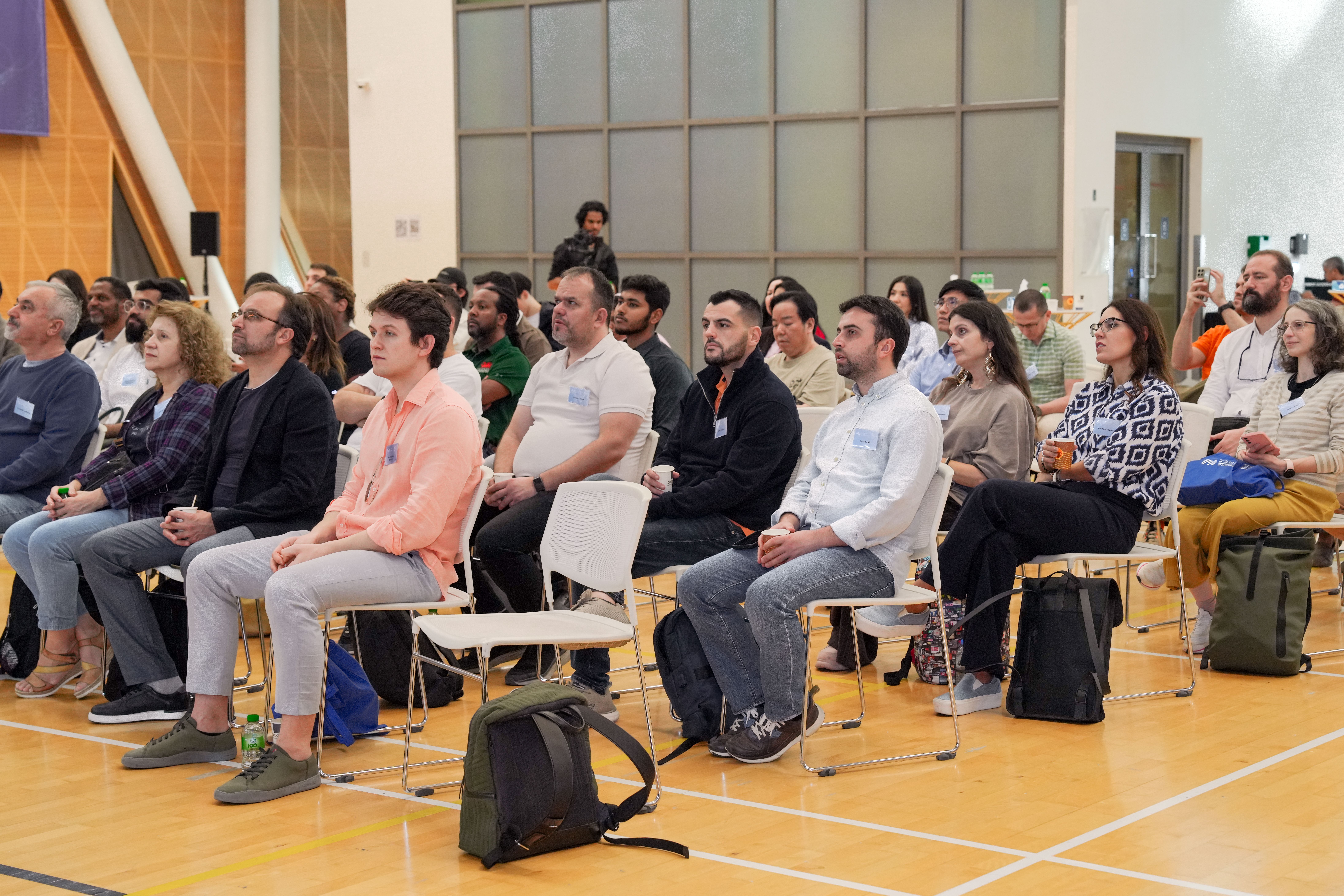 Diverse group listening at a public meeting, representing community participation and trust