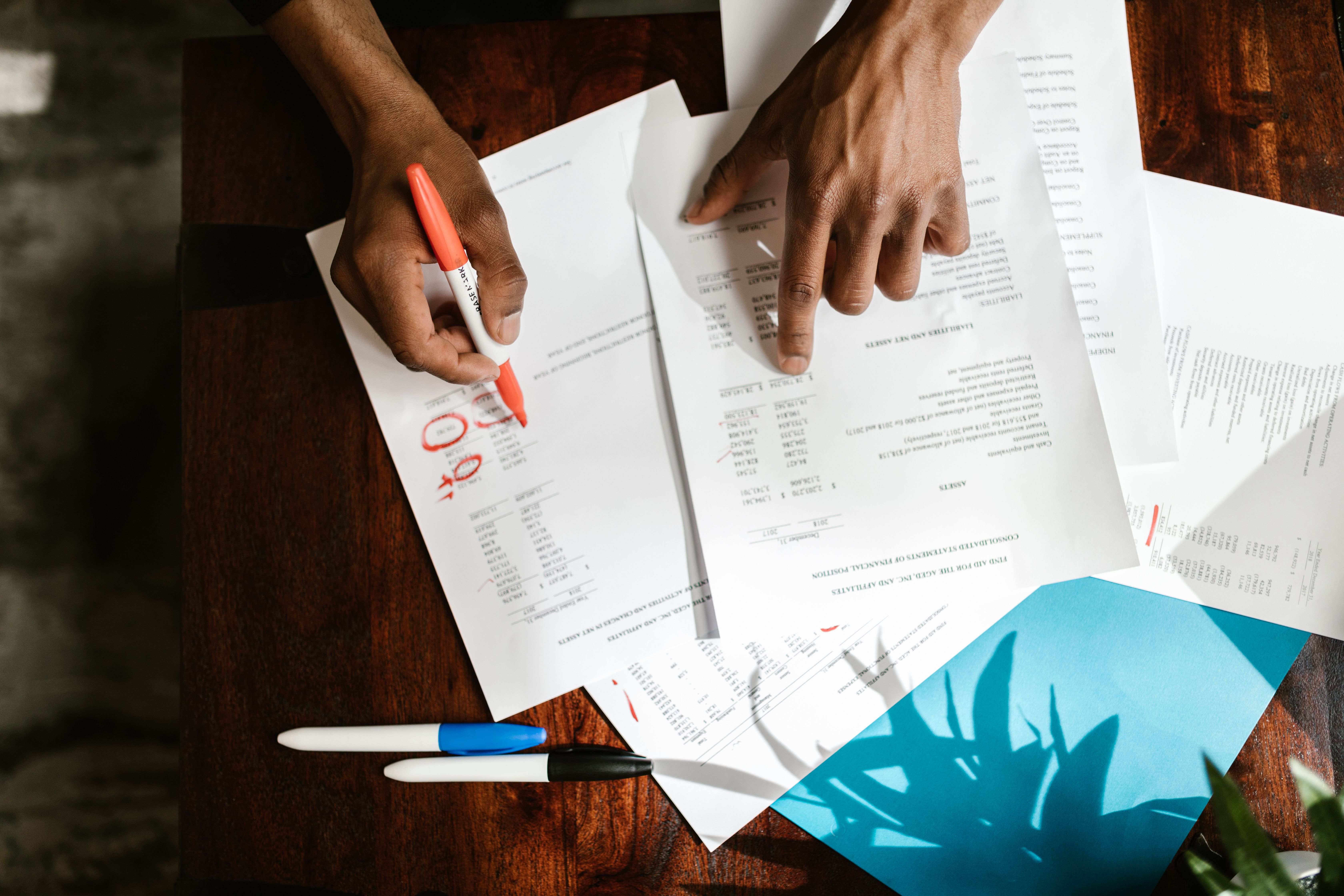 Hands highlighting financial documents, representing transparent audits and accountability